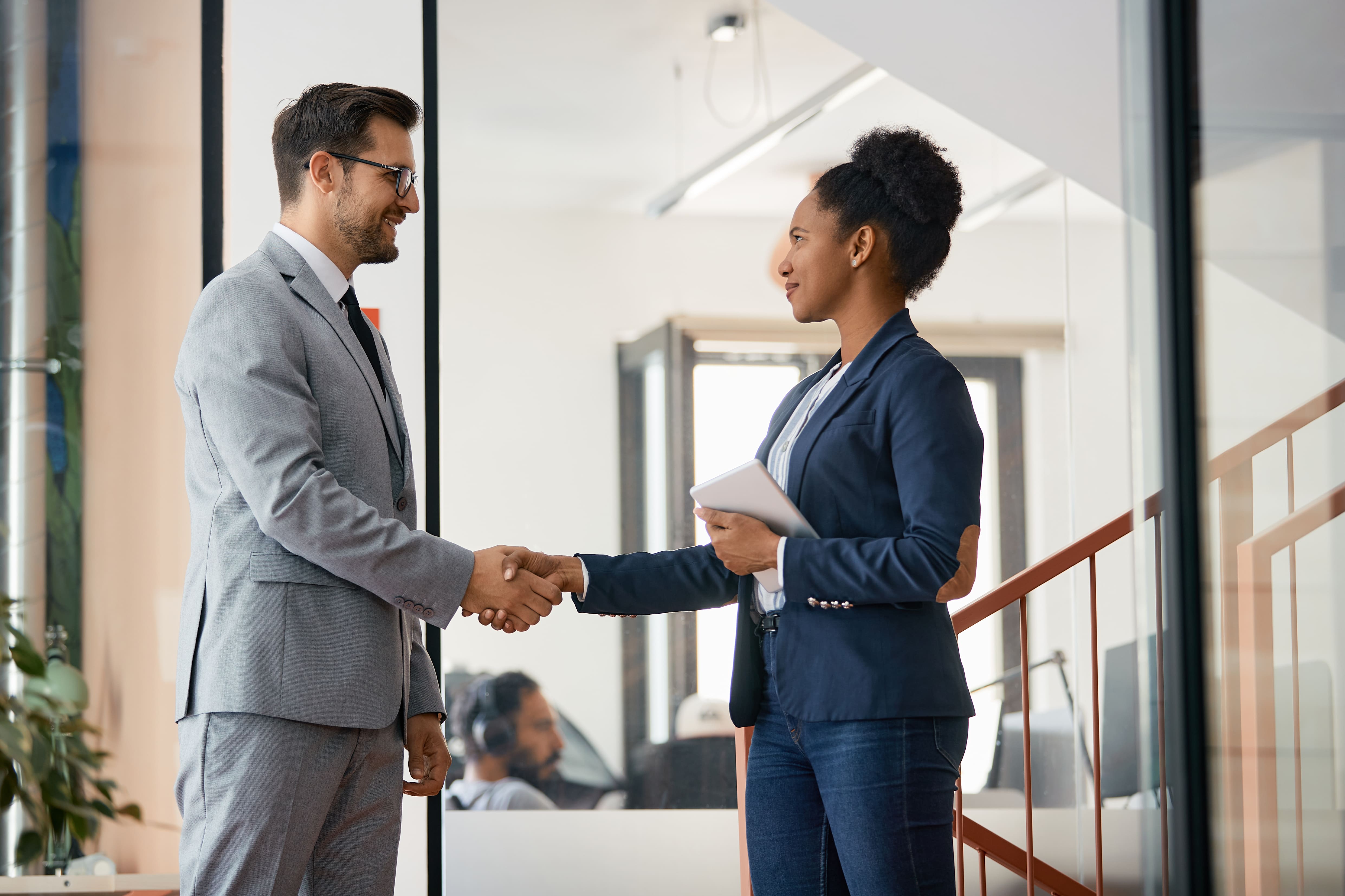 Two professionals shaking hands in an office